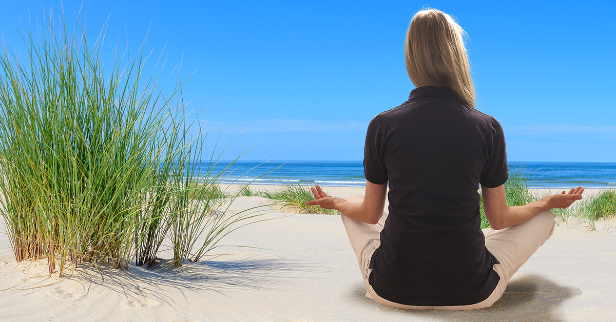 Frau in entspannter Yogaposion am Strand